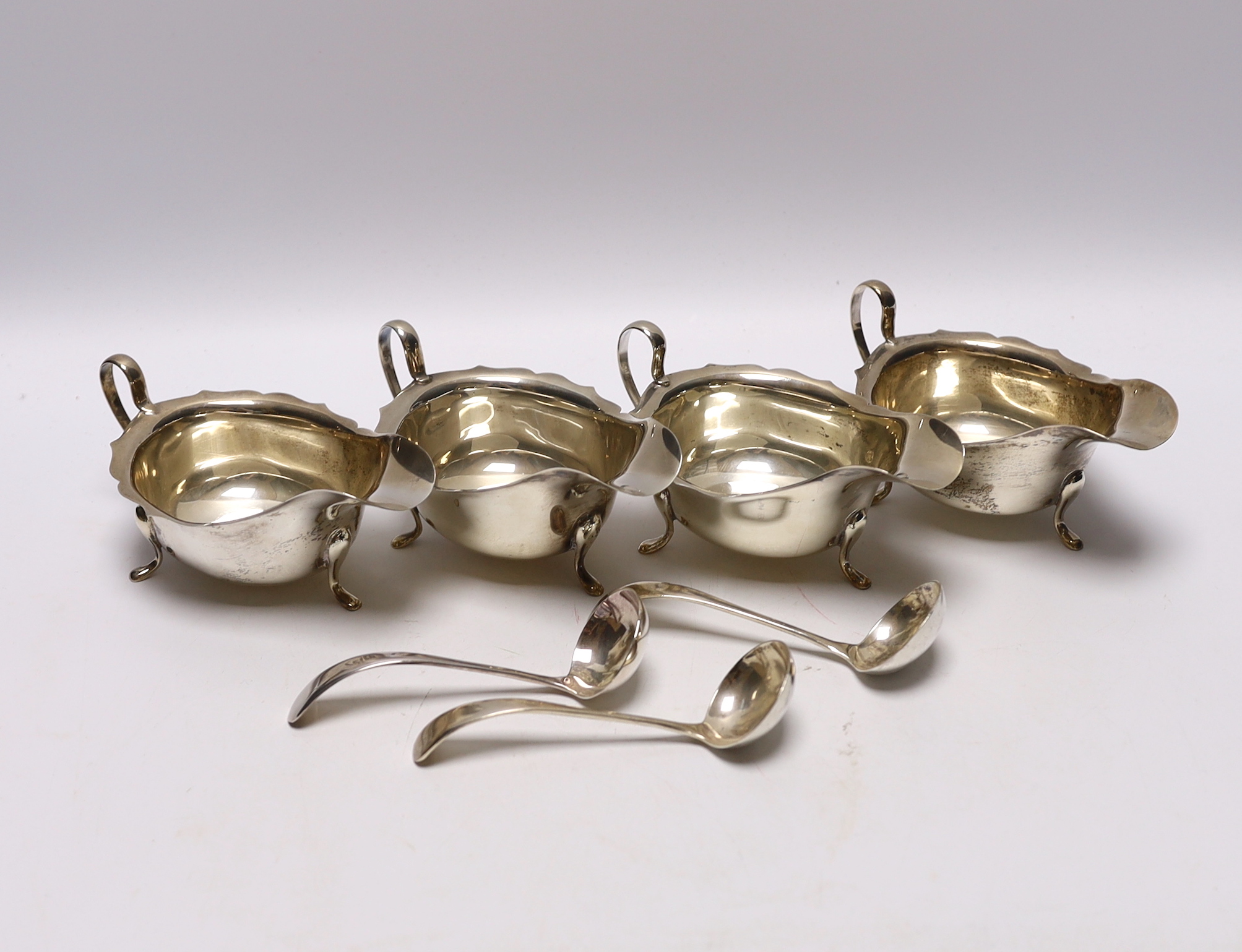 A set of three George VI silver sauceboats, Viners Ltd, Sheffield, 1937, together with three ladles (two silver) and one other silver sauceboat, 16.1oz.